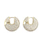 A pair of gold pave-set diamond huggie hoop earrings sparkles against a clean white background.