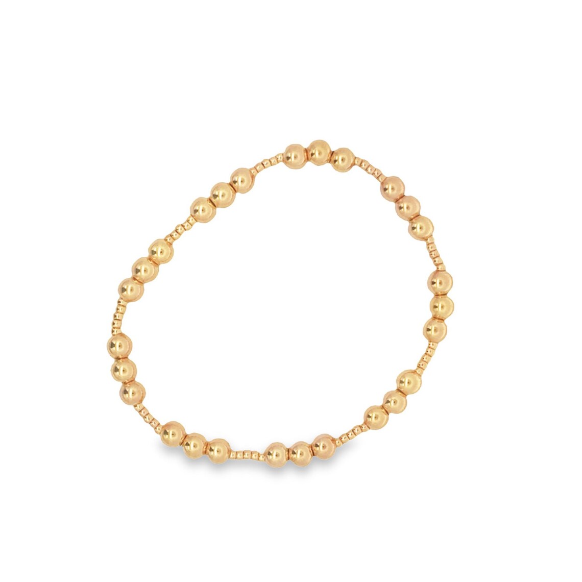 A minimalist gold bead bracelet rests in a clean circle on a plain white background.