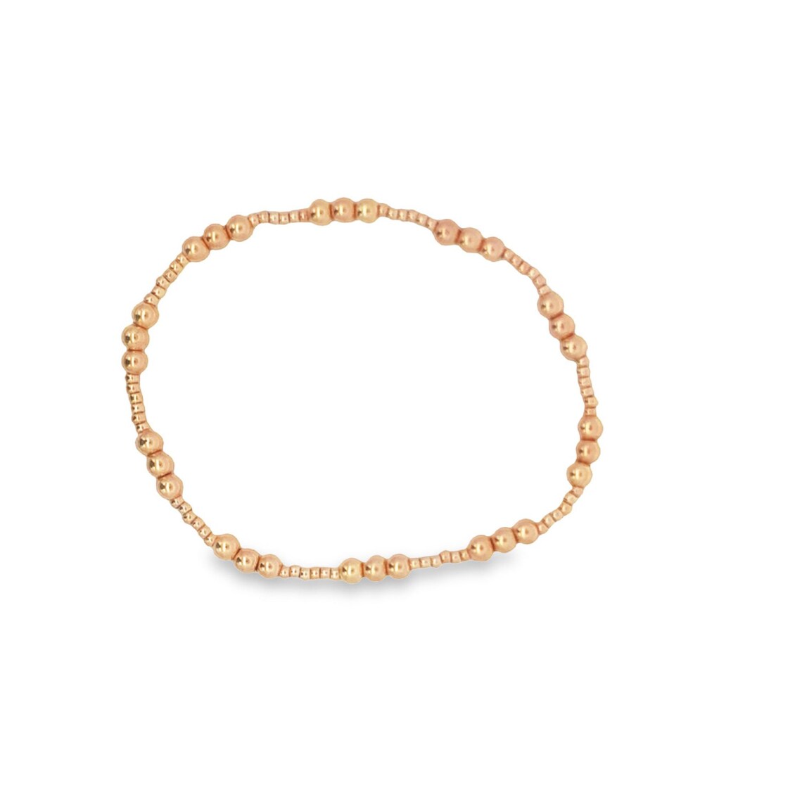 A dainty rose gold bead bracelet rests in a circle on a clean white background.