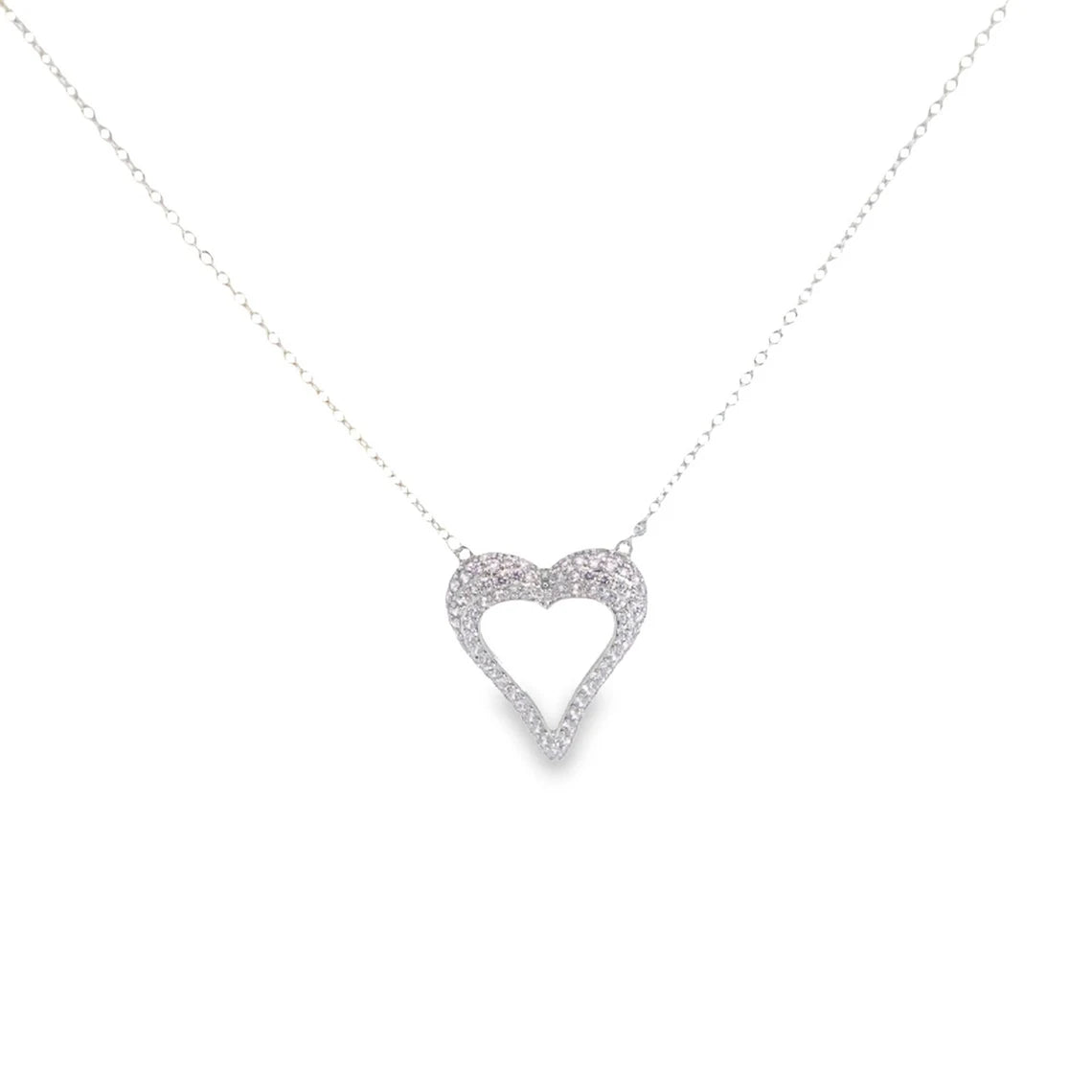 A delicate silver chain hangs against a plain background, holding a sparkling diamond heart pendant.
