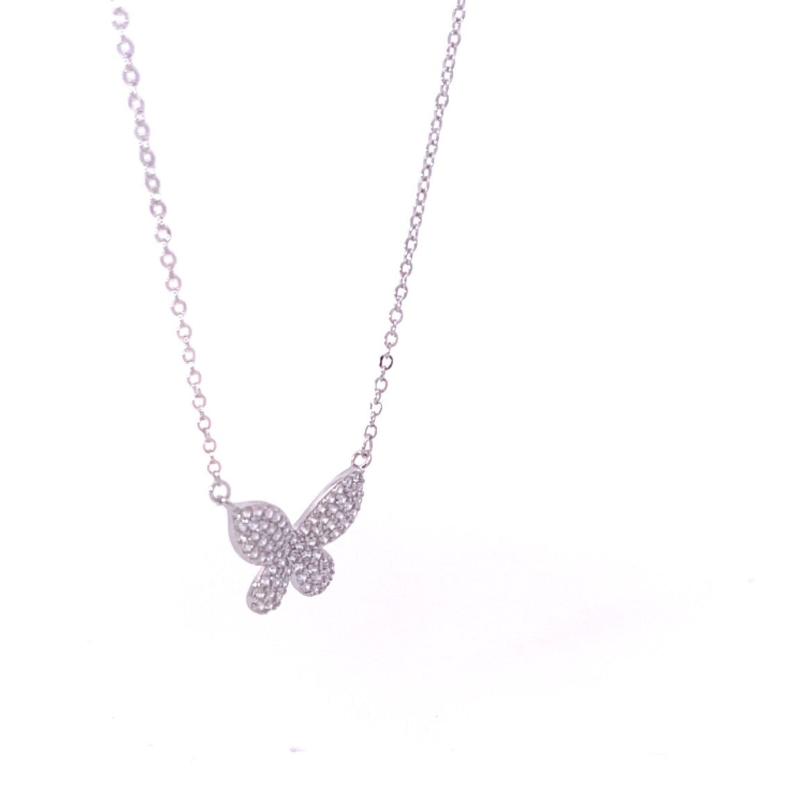 A delicate silver butterfly pendant necklace sparkles with pavé crystals on a fine chain against a white background.