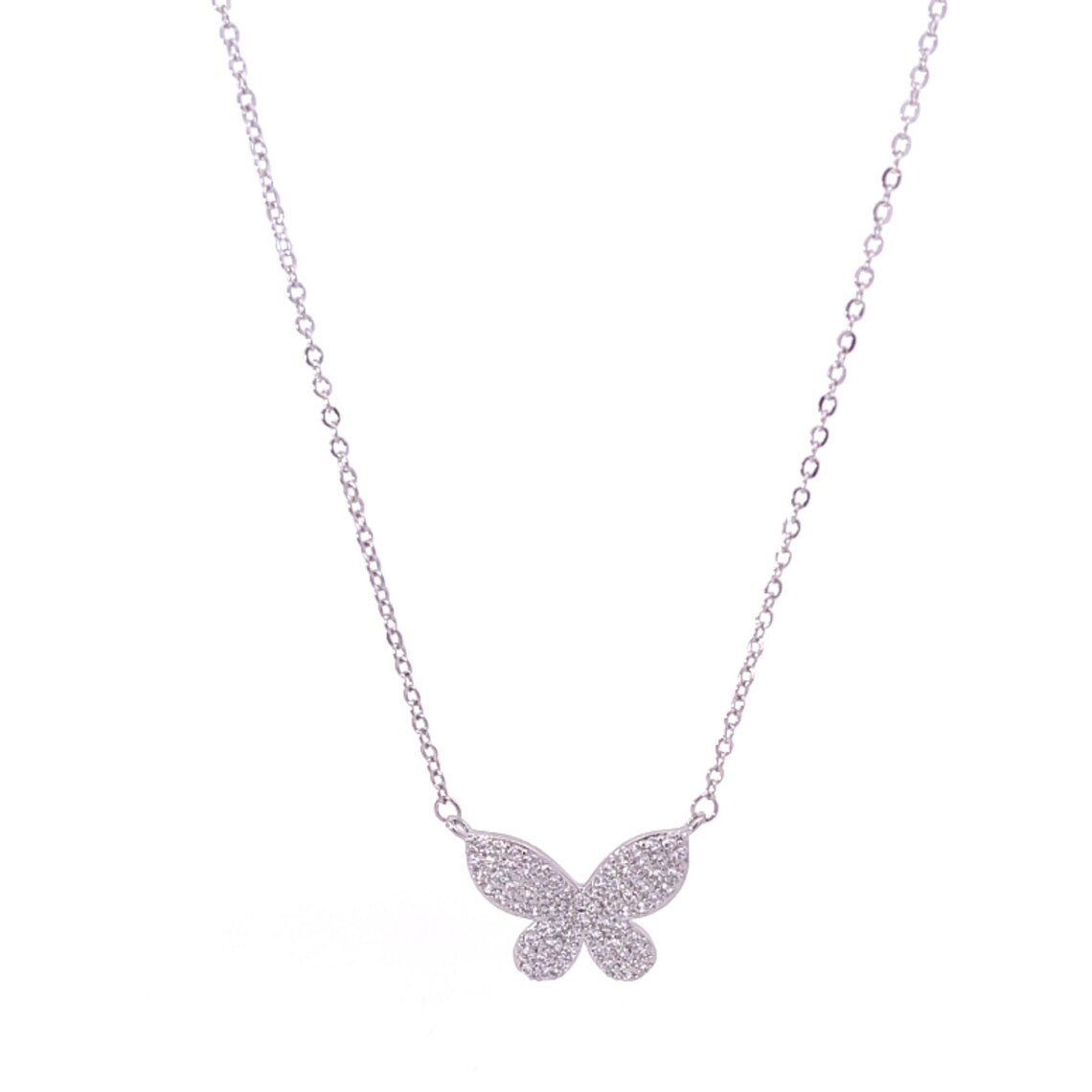 A delicate silver chain necklace features a sparkling, pavé-set crystal butterfly pendant suspended on a clean white background.