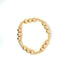 A gold beaded stretch bracelet rests against a plain white background, showcasing shiny metallic beads of graduating sizes.