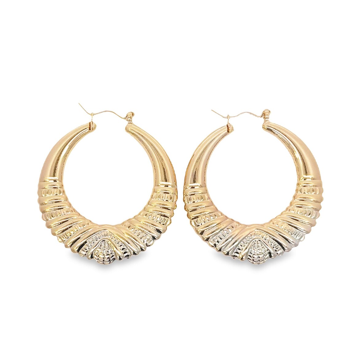 A pair of textured gold and silver hoop earrings rest against a plain white background.