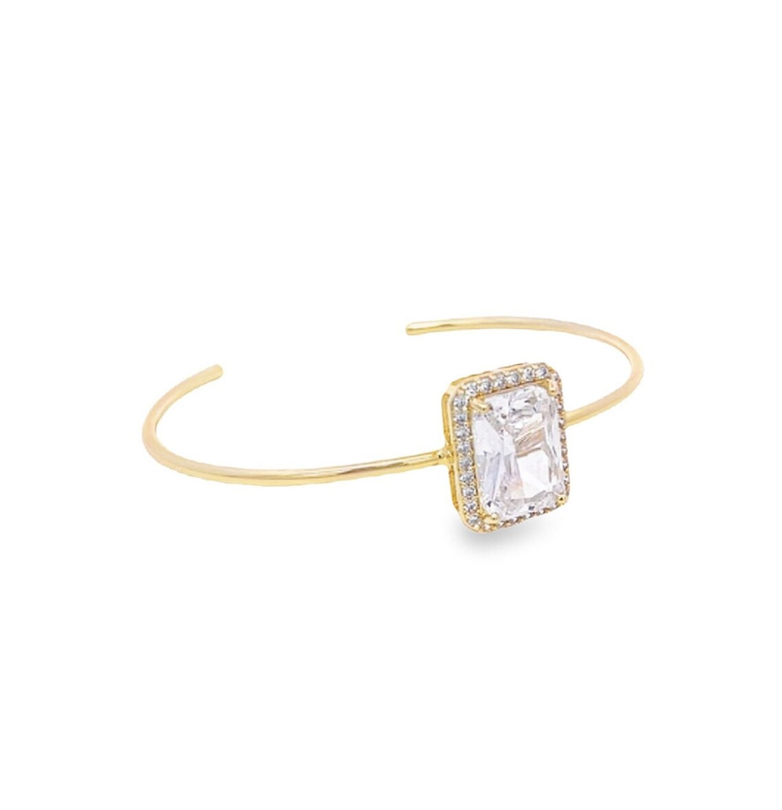 A delicate gold cuff bracelet features a large emerald-cut diamond accented by a sparkling pavé halo.