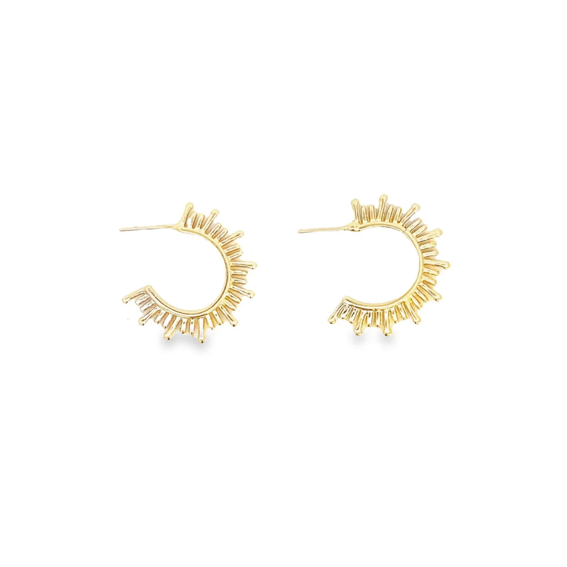 A pair of gold sunburst hoop earrings lie flat against a white background.