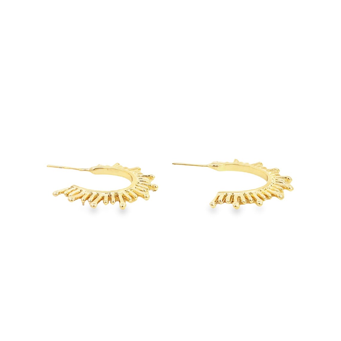A pair of gold sunburst hoop earrings rests on a clean white background.