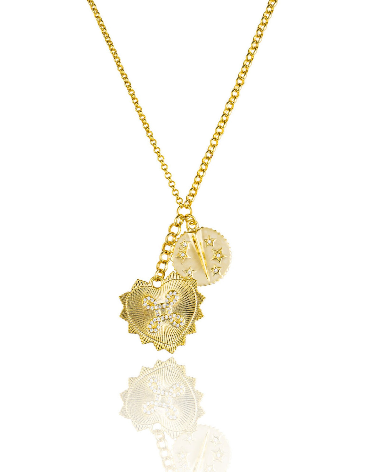 A gold chain necklace displays a diamond-encrusted heart pendant and a celestial coin charm with star details against a white reflective background.
