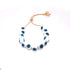 A delicate gold-toned adjustable slider bracelet features a string of white and blue glass evil eye beads against a plain white background.
