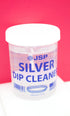 A jar of JSP silver dip cleaner sits against a bright pink background.
