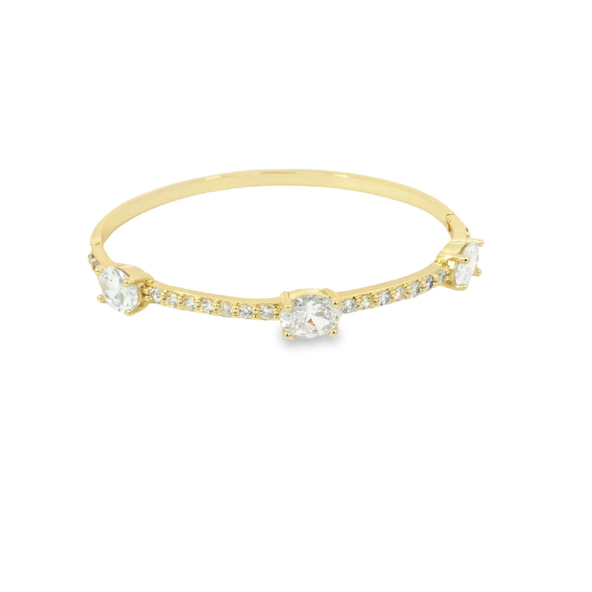 A delicate yellow gold bangle bracelet features three prominent bezel-set diamonds and a pavé of smaller diamonds against a clean white background.