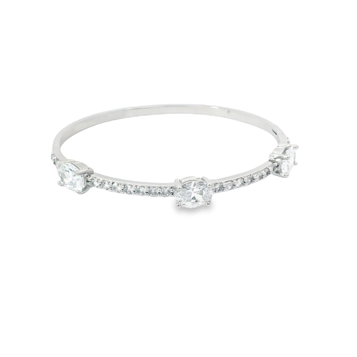 A silver diamond bangle features three prominent larger stones and pavé-set diamonds along the band against a clean white background.