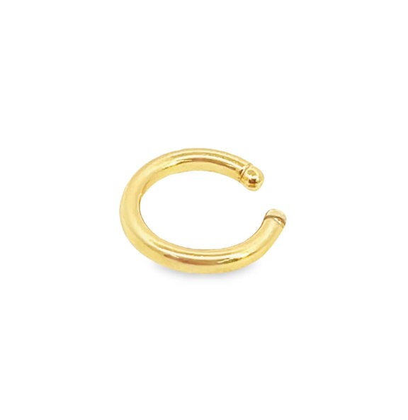 A polished gold hoop ear cuff rests against a clean white background.