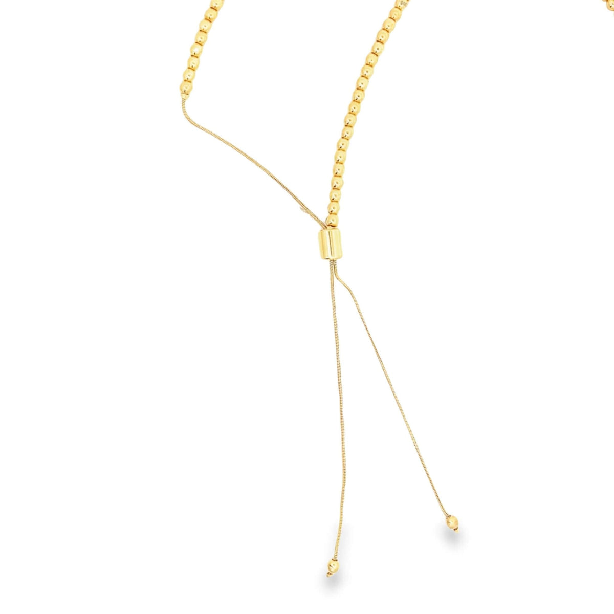 A close-up of a gold adjustable bolo necklace showcases its delicate beaded chain and sliding clasp mechanism against a clean white background.