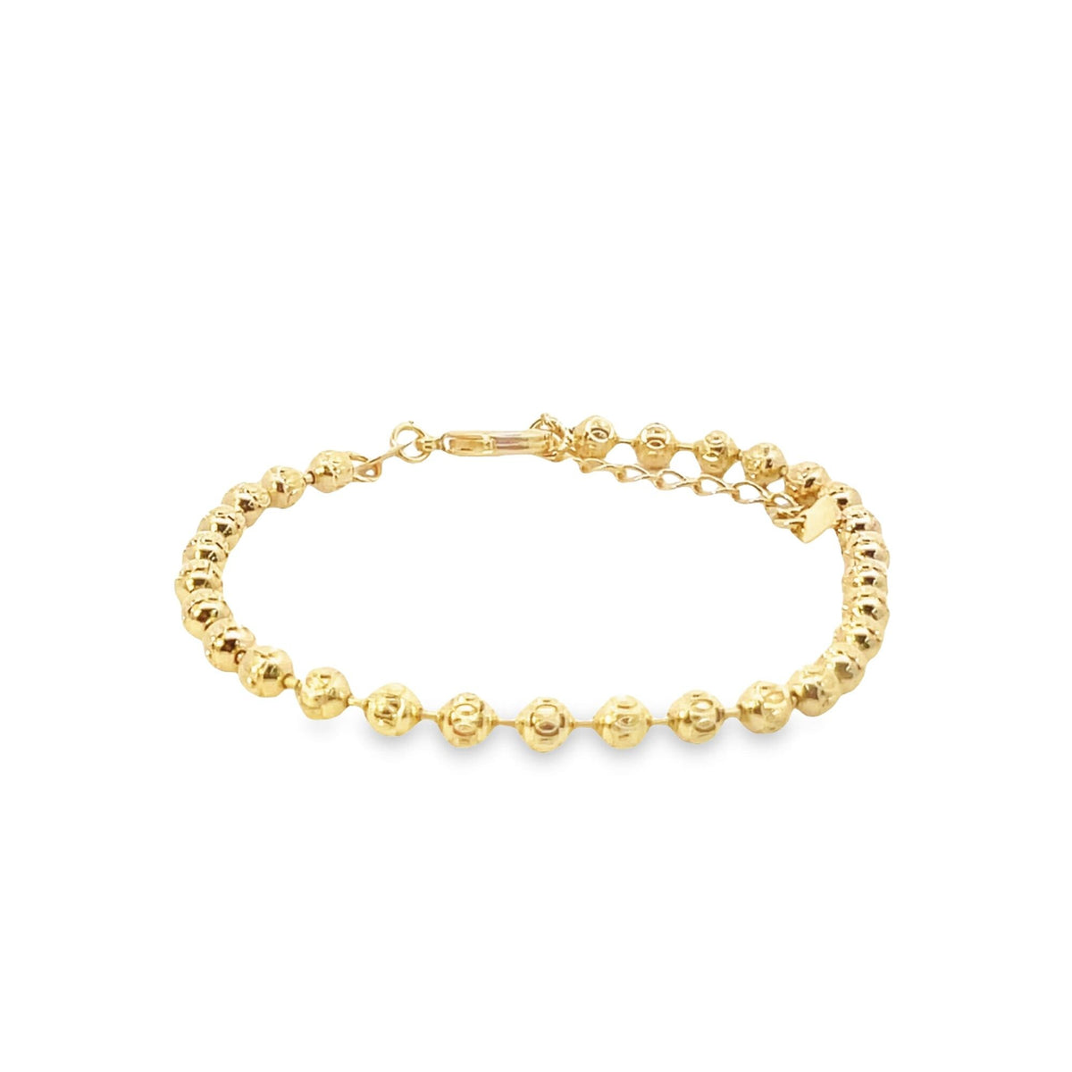 A delicate gold bead bracelet rests horizontally against a clean white background.