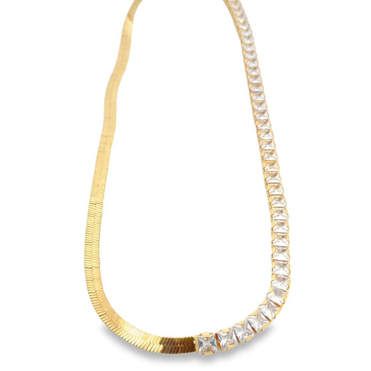 A stylish gold necklace features a split design with a flat herringbone chain on the left and sparkling square-cut stones on the right.