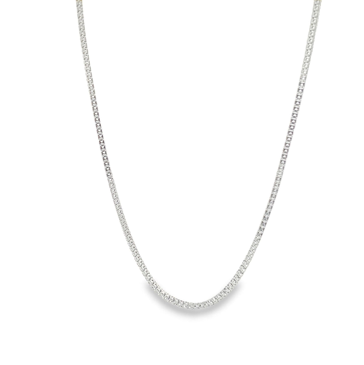 A delicate silver box chain necklace drapes gracefully against a plain white background.