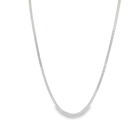 A delicate silver box chain necklace drapes gracefully against a plain white background.