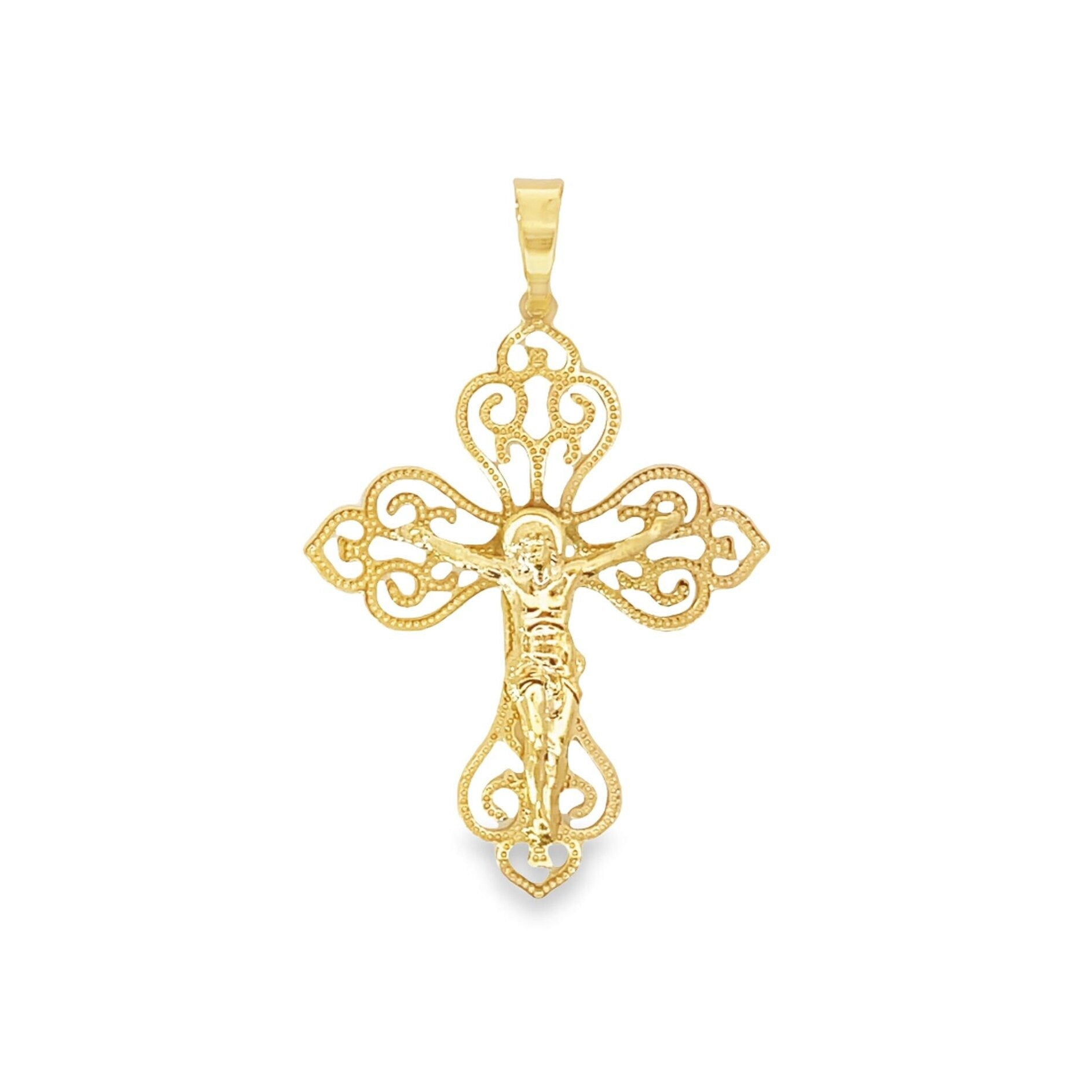 A gleaming gold crucifix pendant features intricate filigree work and scroll designs across a white background.