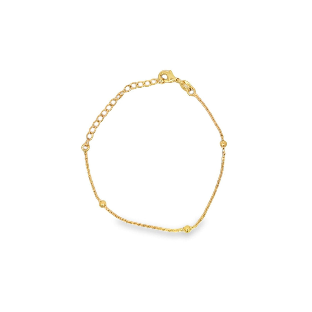 A delicate gold bracelet featuring spaced beads and an adjustable chain lies on a white background.