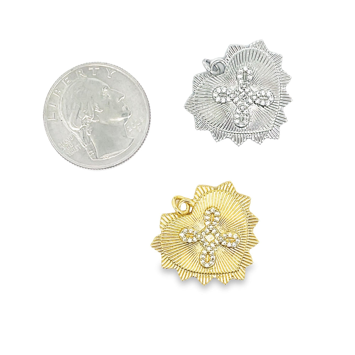 A US quarter rests beside a silver-plated and a gold-plated sacred heart charm, each accented with sparkling cubic zirconia crosses.