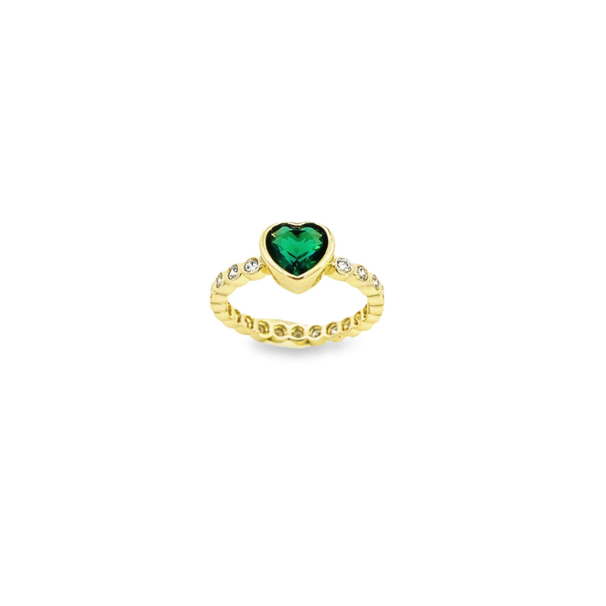 A gold ring features a central heart-shaped green emerald flanked by sparkling diamonds along the band.