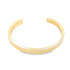 A sleek gold cuff bracelet rests against a clean white background, showcasing its minimalist open design.