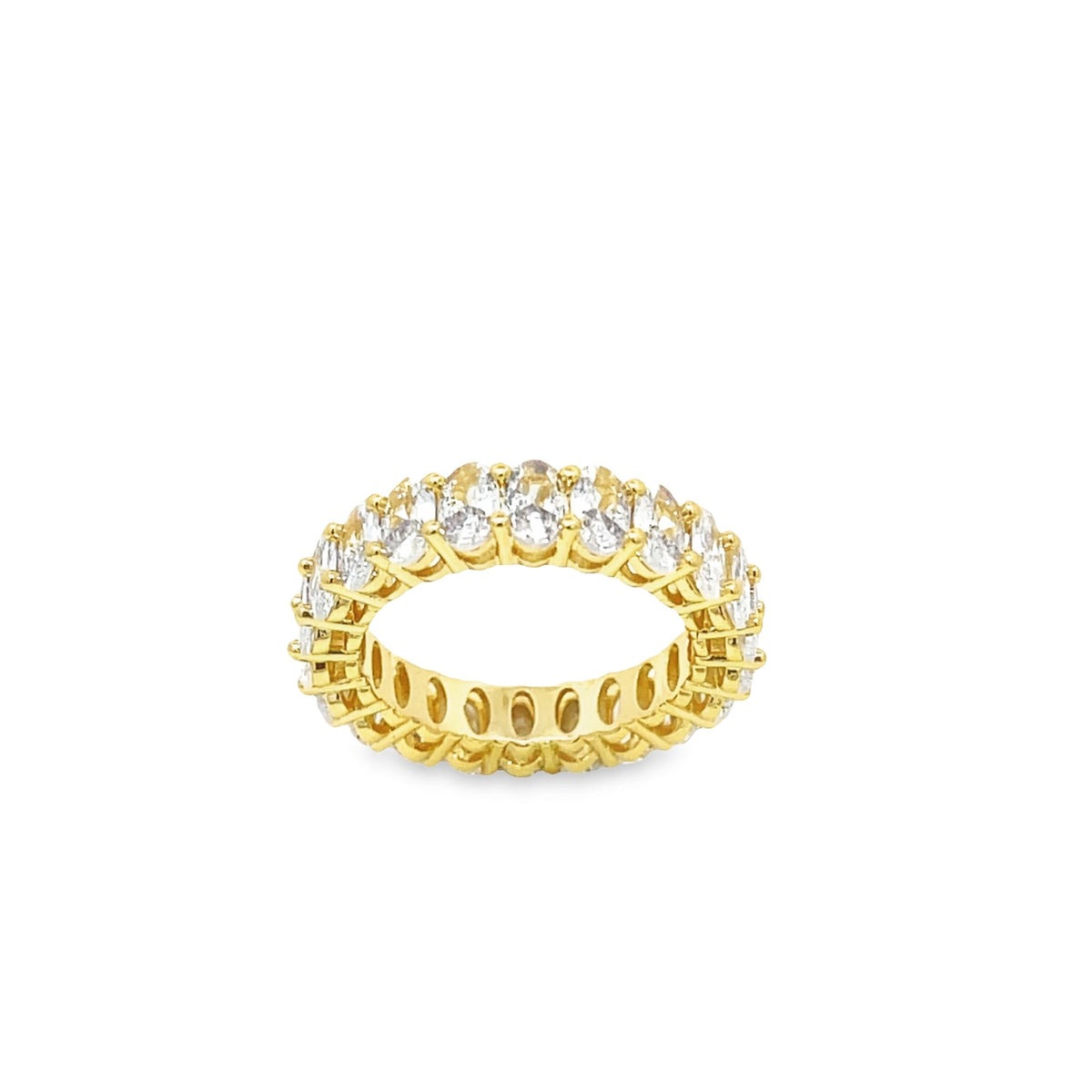 A gold eternity band ring sparkles with a continuous circle of prong-set oval cubic zirconia stones against a clean white background.