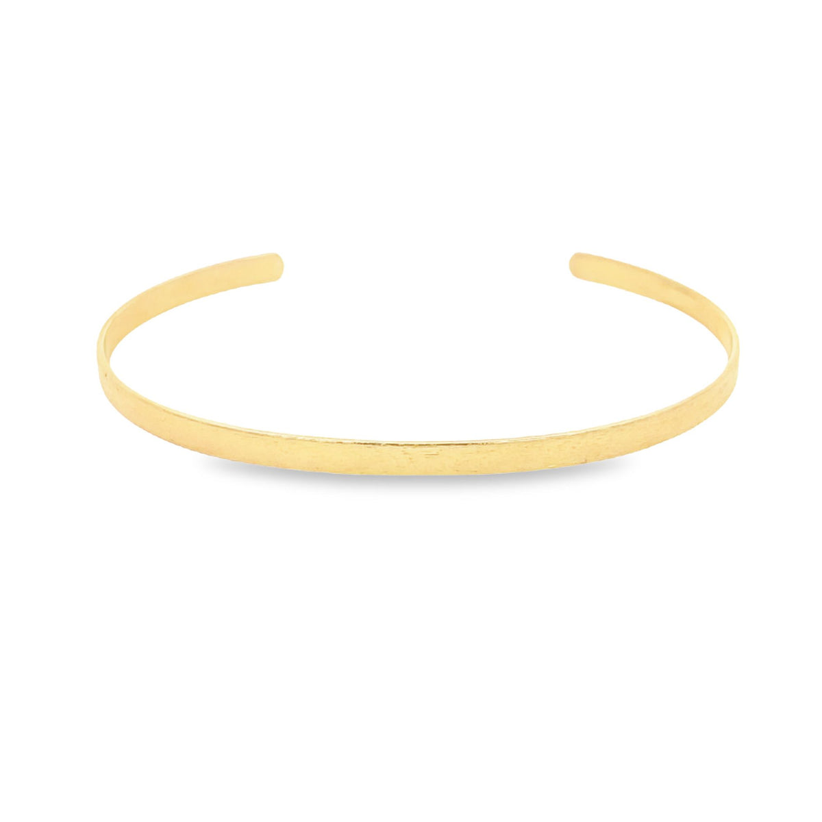 A minimalist gold cuff bracelet rests against a plain white background.