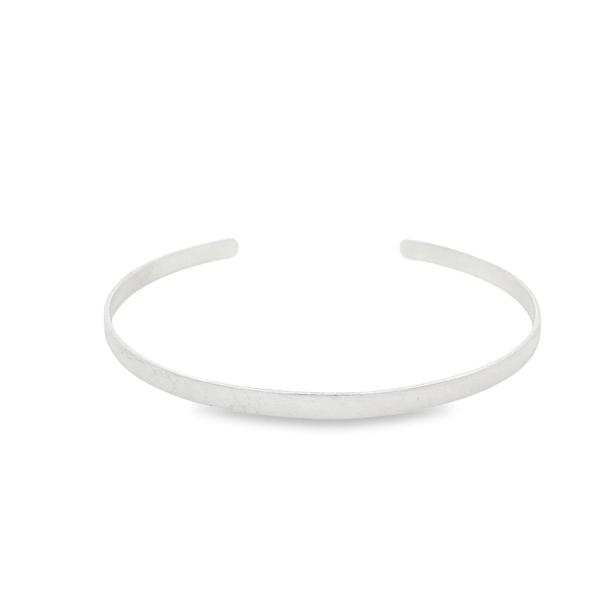 A minimalist sterling silver cuff bracelet rests on a clean white background.