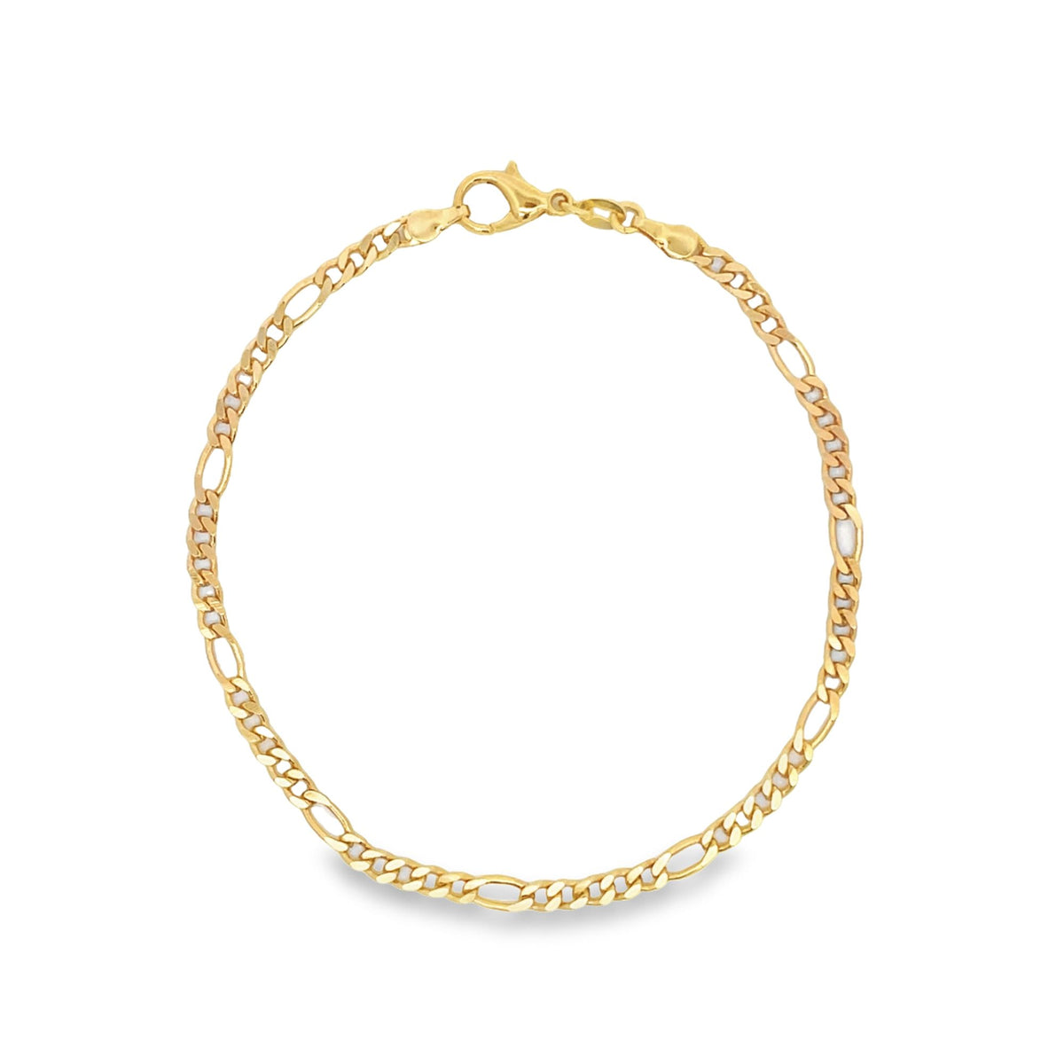 A classic gold Figaro chain bracelet rests in a circle on a white background, displaying its alternating long and short links and a secure lobster clasp.