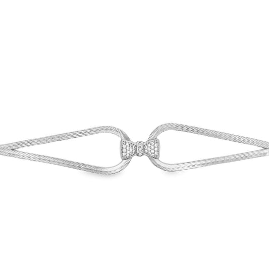 A shimmering silver herringbone chain bracelet features a sparkling diamond-encrusted bow clasp at the center.