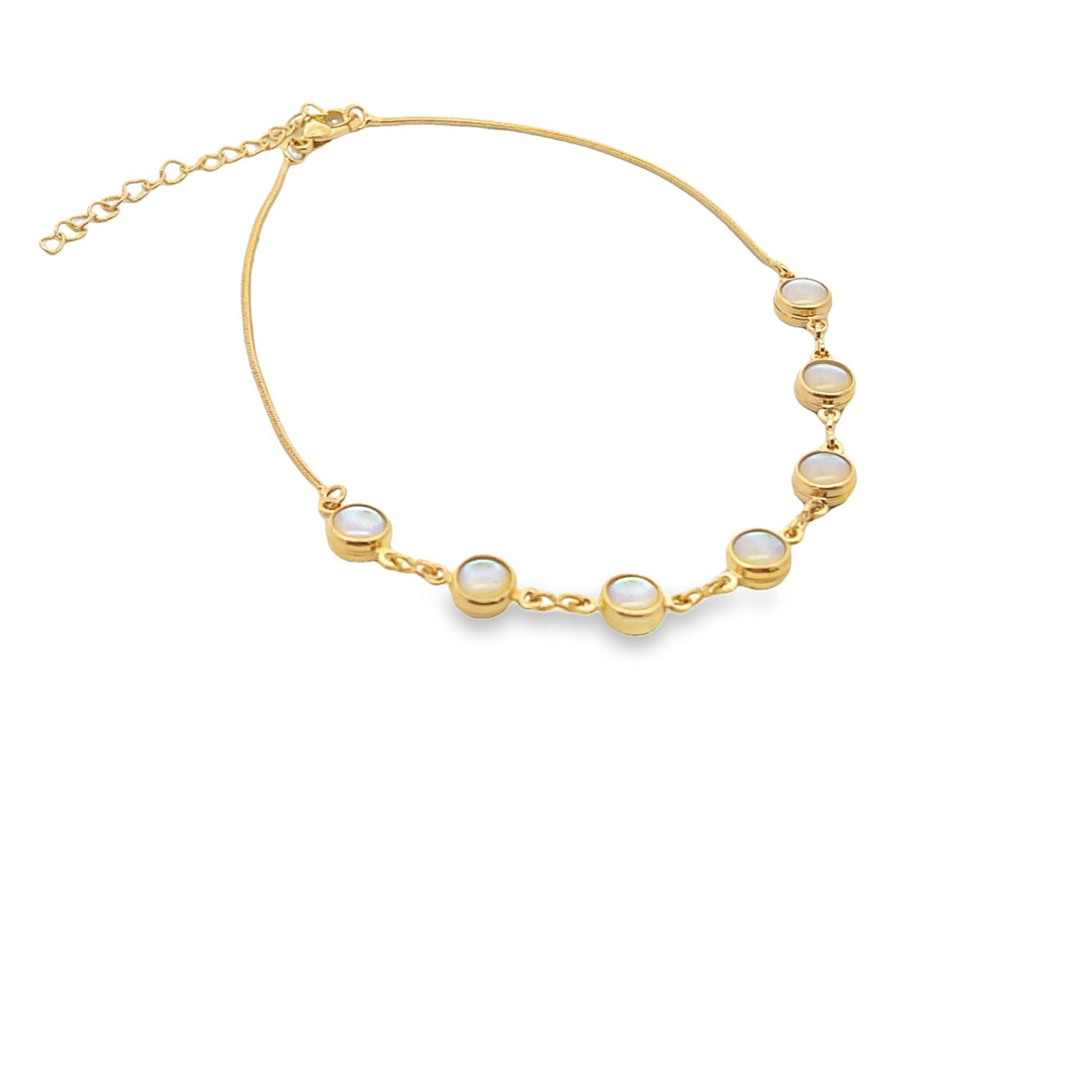 A delicate gold anklet features bezel-set round opal stones along a shimmering chain against a white background.