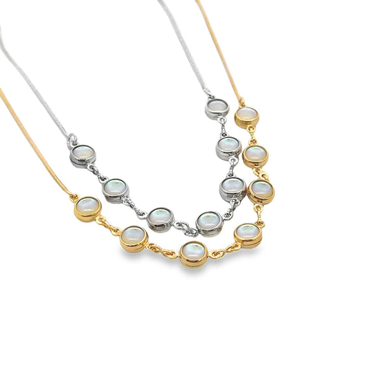 Two layered necklaces featuring bezel-set iridescent opal stones showcase a silver chain and a gold chain against a white background.