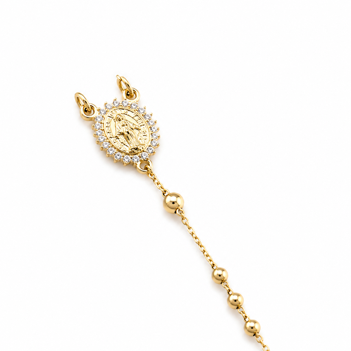 A delicate gold rosary bracelet features a diamond-encrusted Miraculous Medal centerpiece against a clean white background.