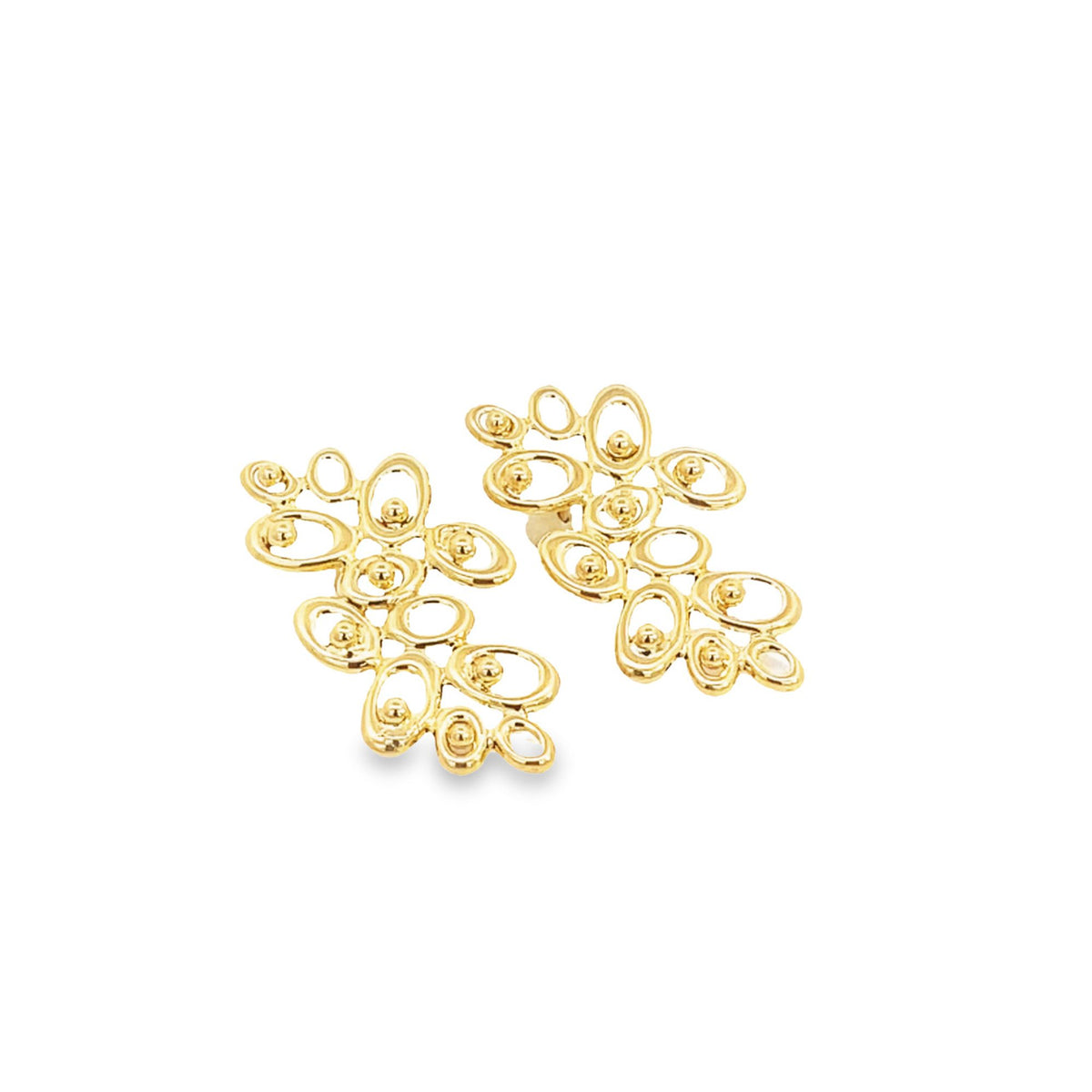 A pair of intricate gold abstract cluster earrings rests against a clean white background.
