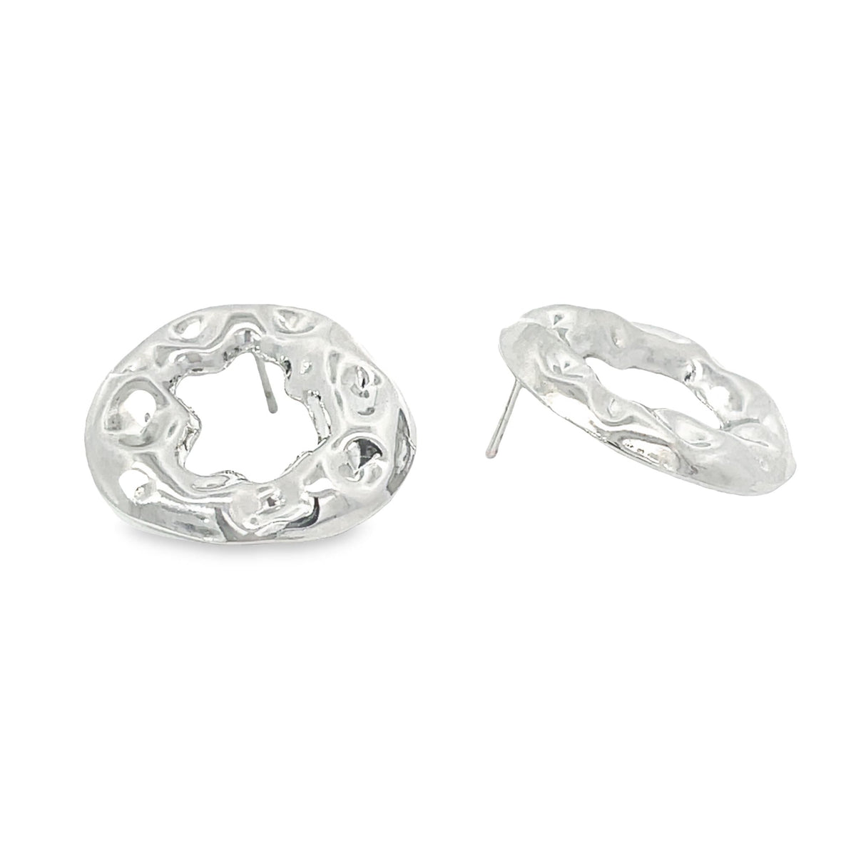 A pair of unique silver stud earrings featuring an organic, hammered texture and an abstract hollow center against a clean white background.