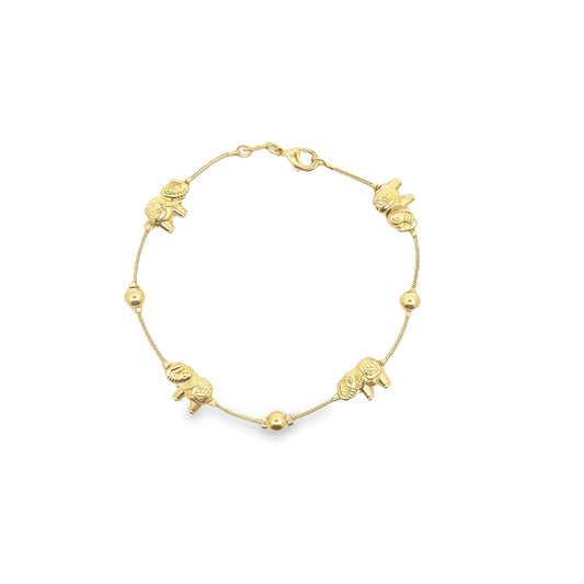 A delicate gold charm bracelet displays alternating elephant charms and golden beads on a fine chain against a white background.