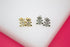 Two pairs of cute gold and silver teddy bear stud earrings feature sparkling cubic zirconia bellies on a white display surface.