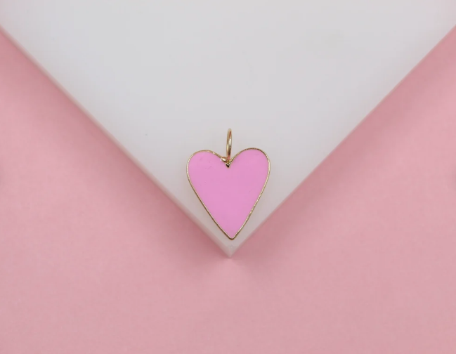A delicate pink enamel heart pendant rests gracefully against a white and pink background.