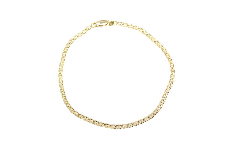 A thin, polished gold Mariner chain bracelet rests in a circle on a white background.