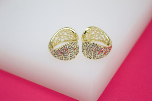 Two gold pave hoop earrings sparkle on a white display stand.