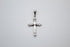 A polished silver cross pendant featuring decorative ribbed ends hangs centered against a plain light gray background.