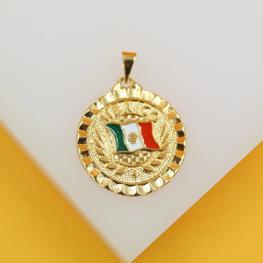 A round gold pendant featuring an enameled Mexican flag rests against a white and yellow background.