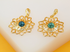 Two gold lotus flower pendants featuring central turquoise stones and sparkling cubic zirconia accents rest side by side on a light surface.