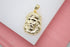 A polished gold Jesus face pendant rests on a white display surface.
