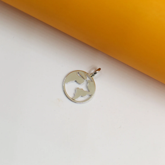 A polished silver globe pendant rests on a clean white surface against an orange and white background.