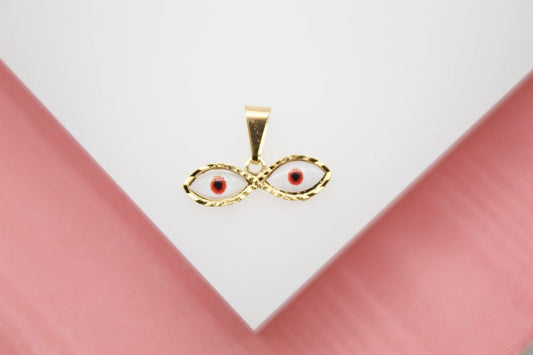 A gold evil eye pendant features white enamel and a central red and black pupil design against a white and pink background.