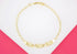 A gold link chain bracelet features three rectangular charms with embossed elephant designs against a pink and white background.