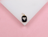 A gold pendant features a black rectangular frame with a sparkling pave-set diamond heart at its center.